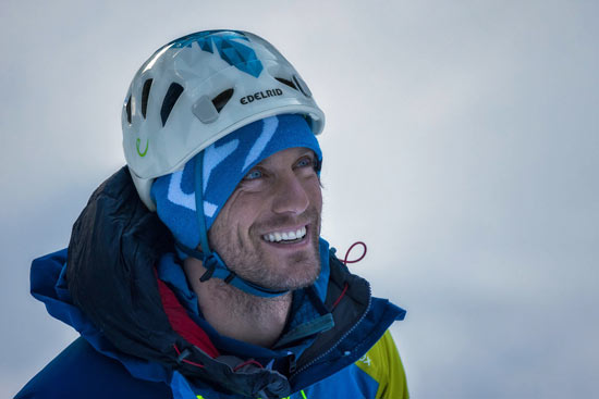 Kletterer steht vor einem gefrorenen Wasserfall Kletterer steht vor einem gefrorenen Wasserfall
